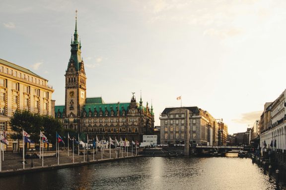 Hamburg Historisches Hamburger Rathaus und Kanal bei Sonnenuntergang.