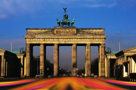 Berlin Das Brandenburger Tor bei Sonnenuntergang, mit bunten Lichtern im Vordergrund.