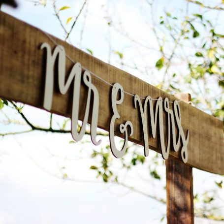 Feste in und um Hamburg Holzschild mit der Aufschrift "Mr & Mrs" vor einem unscharfen Hintergrund.