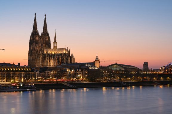 Köln Kölner Dom bei Sonnenuntergang, beleuchtet am Rheinufer.